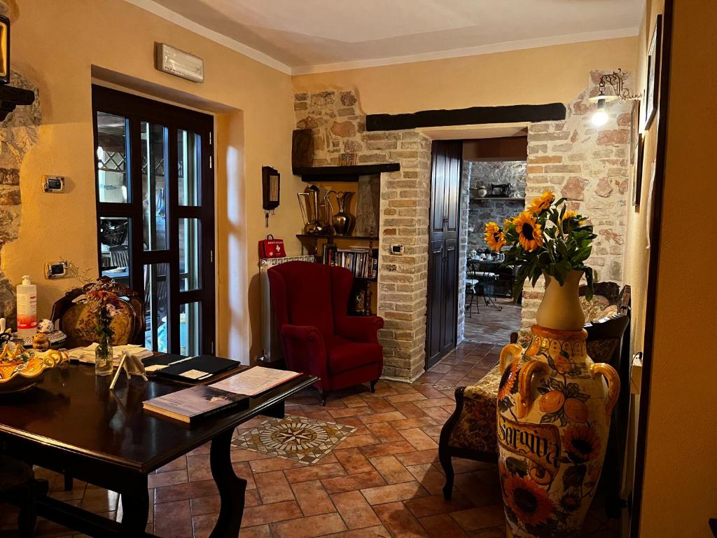 a living room with a table and a red chair at B&B Il Rifugio in Bastia Umbra