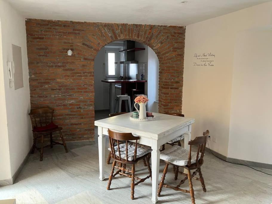 uma mesa e cadeiras num quarto com uma parede de tijolos em Casa Amélie em Caslano
