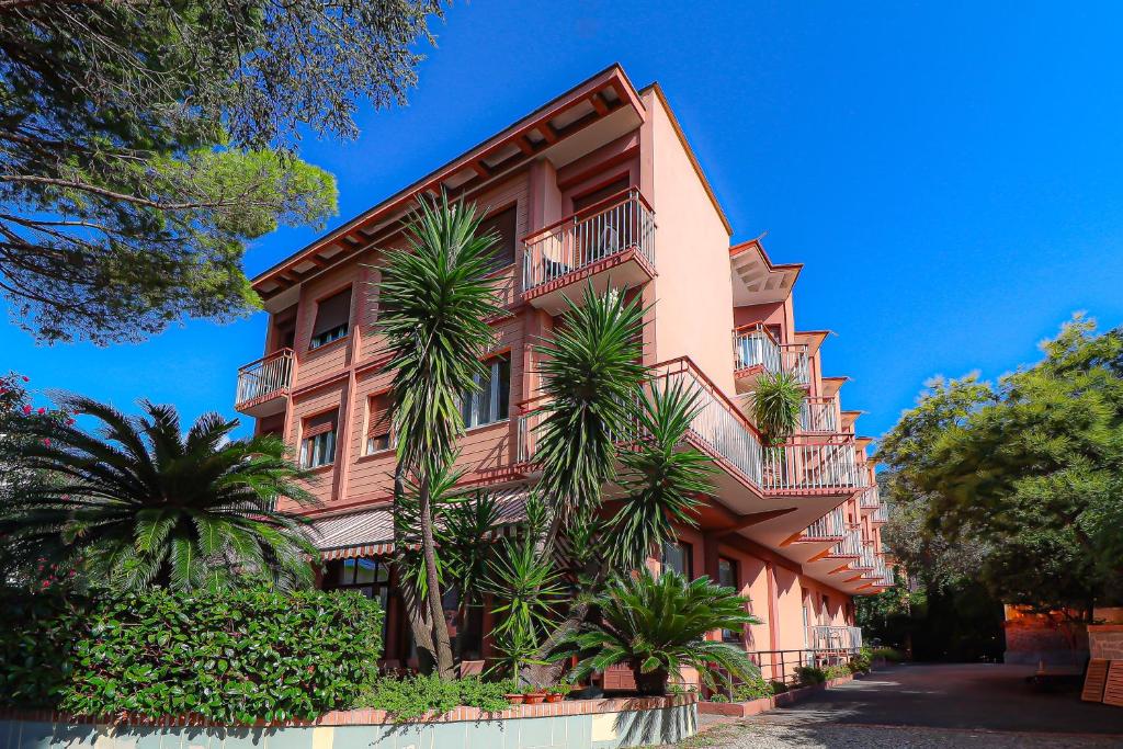un edificio con palme di fronte ad esso di Hotel Esperia a Genova
