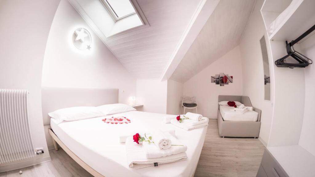 een witte slaapkamer met een wit bed en een dakraam bij Appartamento Stella in Andalo