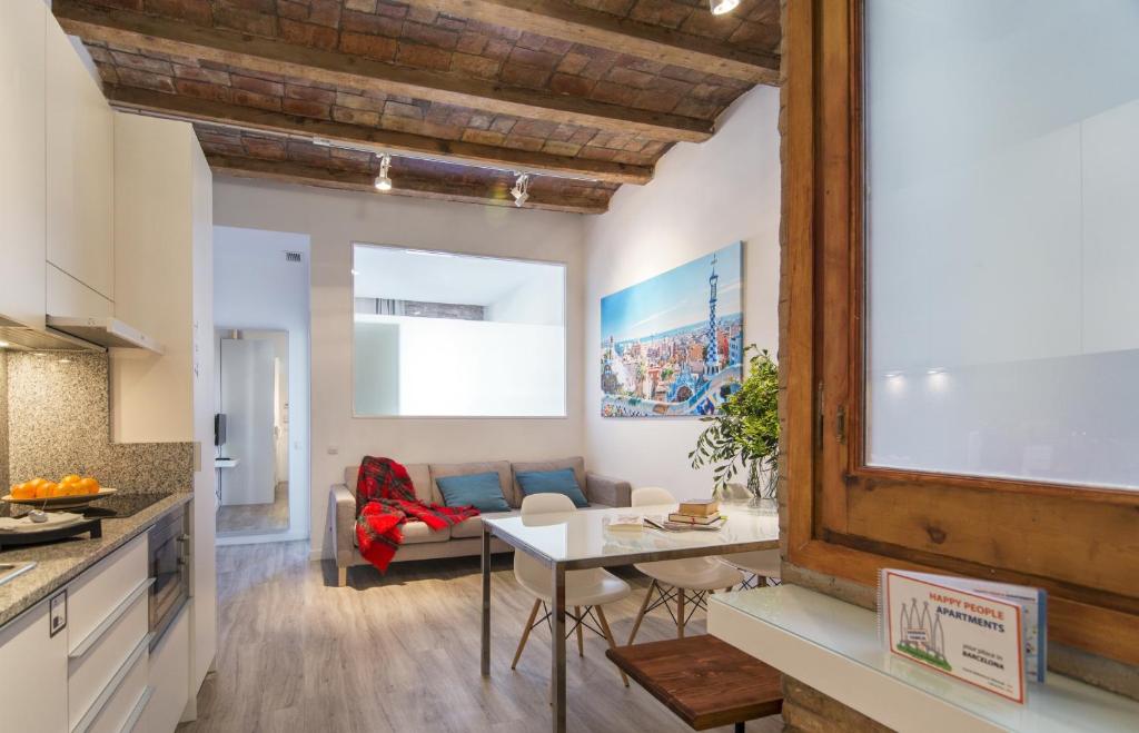 a kitchen and living room with a table and a couch at Happy People Sagrada Familia Apartments in Barcelona