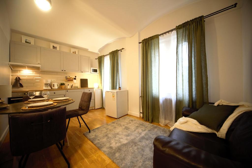 een woonkamer met een bank en een tafel en een keuken bij Valnu street Old Town - quiet area in Rīga