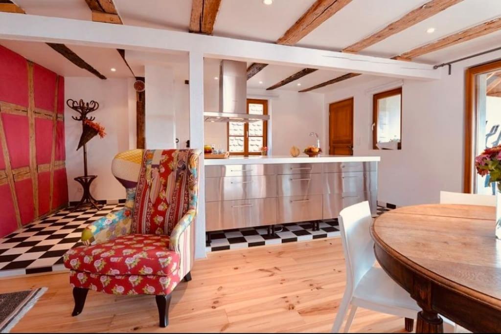 a kitchen with a table and chairs and a counter at Gîte Origin Gueberschwihr in Gueberschwihr