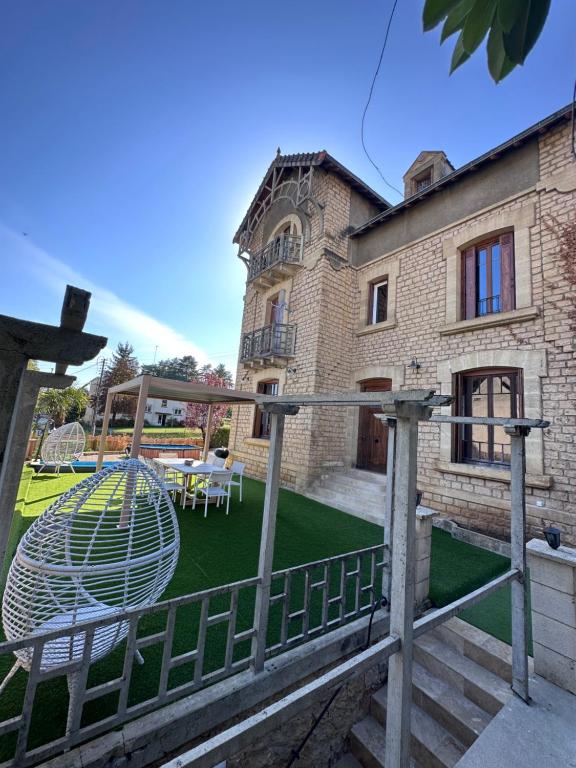 un bâtiment avec une cour et une aire de jeux dans l'établissement Maison de ville Duplex Artienzo, à Sarlat-la-Canéda