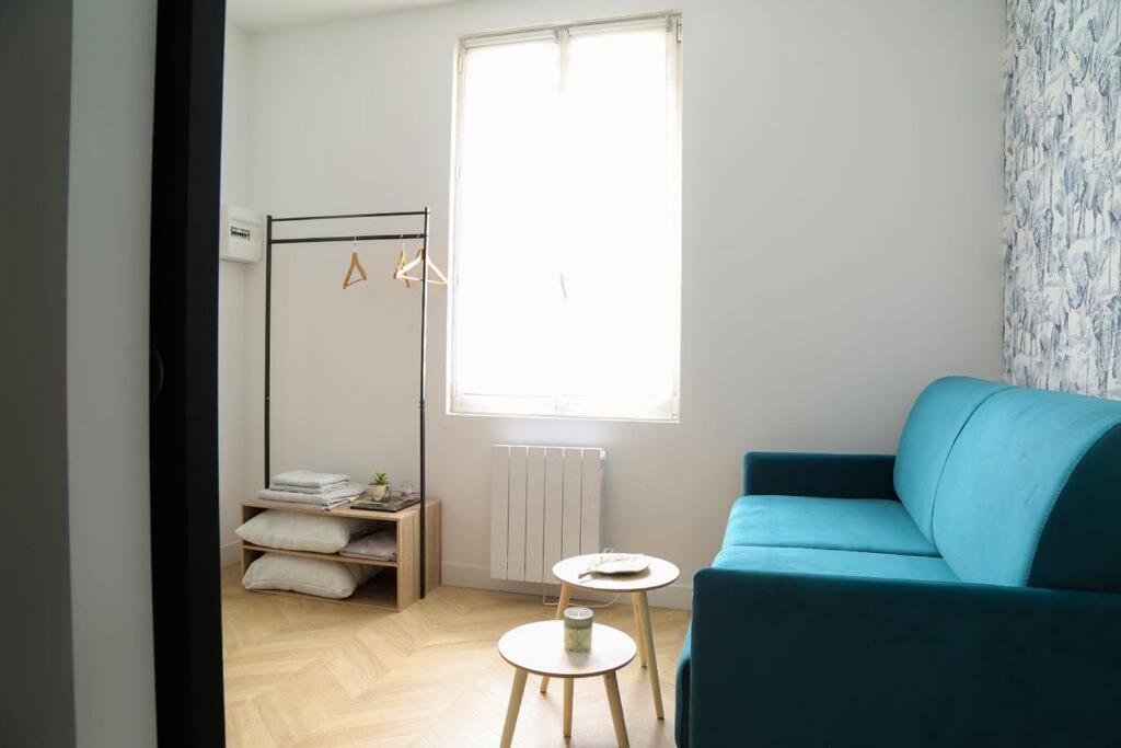 - un salon avec un canapé bleu et une table dans l'établissement L'écrin avec salle de sport, à Rouen