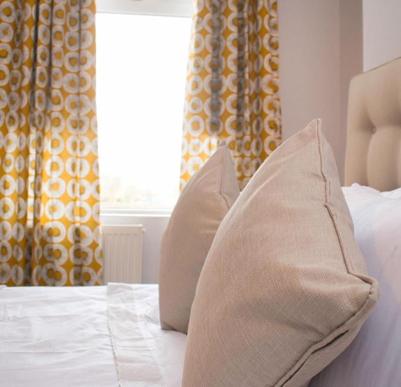 a bed with two pillows on it with a window at Paradise House Darlington in Darlington