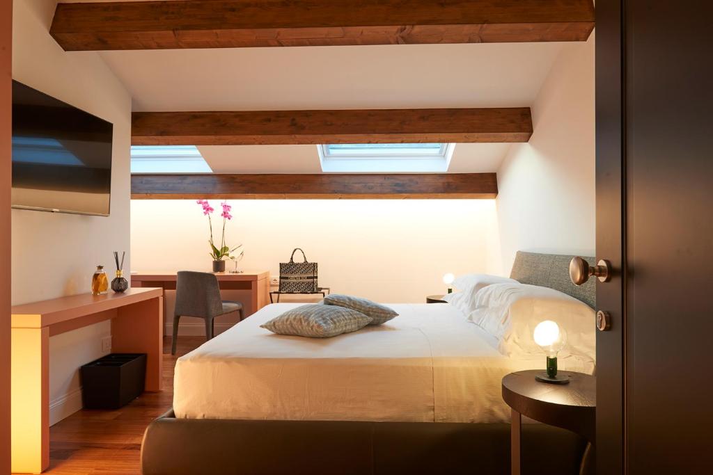 a bedroom with a bed and a desk and a table at Relais - Palazzo Greco Stella in Lamezia Terme