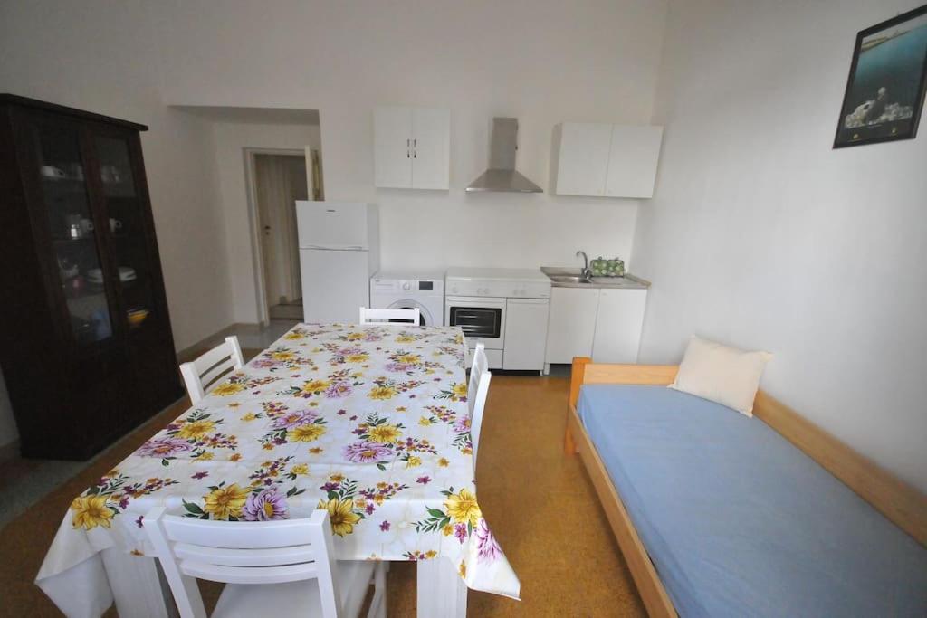 Il dispose d'une cuisine avec une table et des chaises. dans l'établissement Villa Muia-Appartamento con giardino, à Parabita