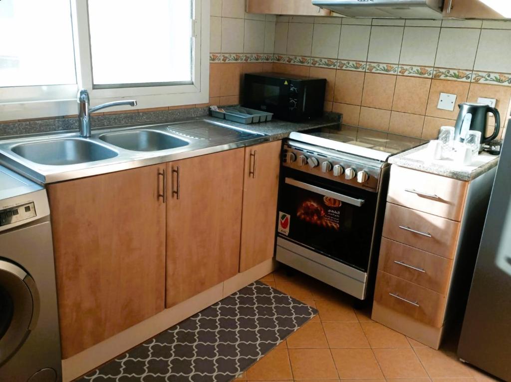 cocina pequeña con fregadero y fogones en Marbella Holiday Homes - Al Nahda 1BHK, en Dubái