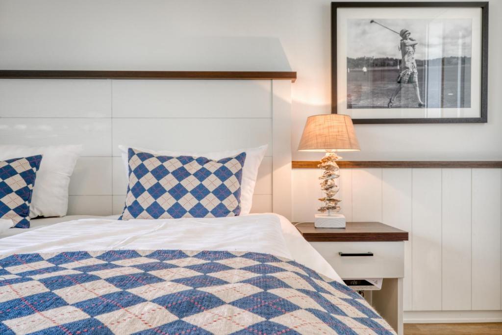 Un dormitorio con una cama azul y blanca y una lámpara en Ferienwohnungen Strandgrün, en Timmendorfer Strand