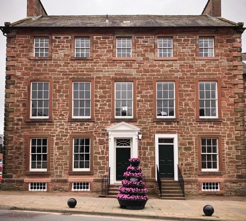 a brick building with a christmas tree in front of it at Bridge View in Annan