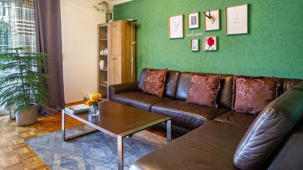 sala de estar con sofá de cuero y mesa en Ferienwohnung Arenda, en Munzingen