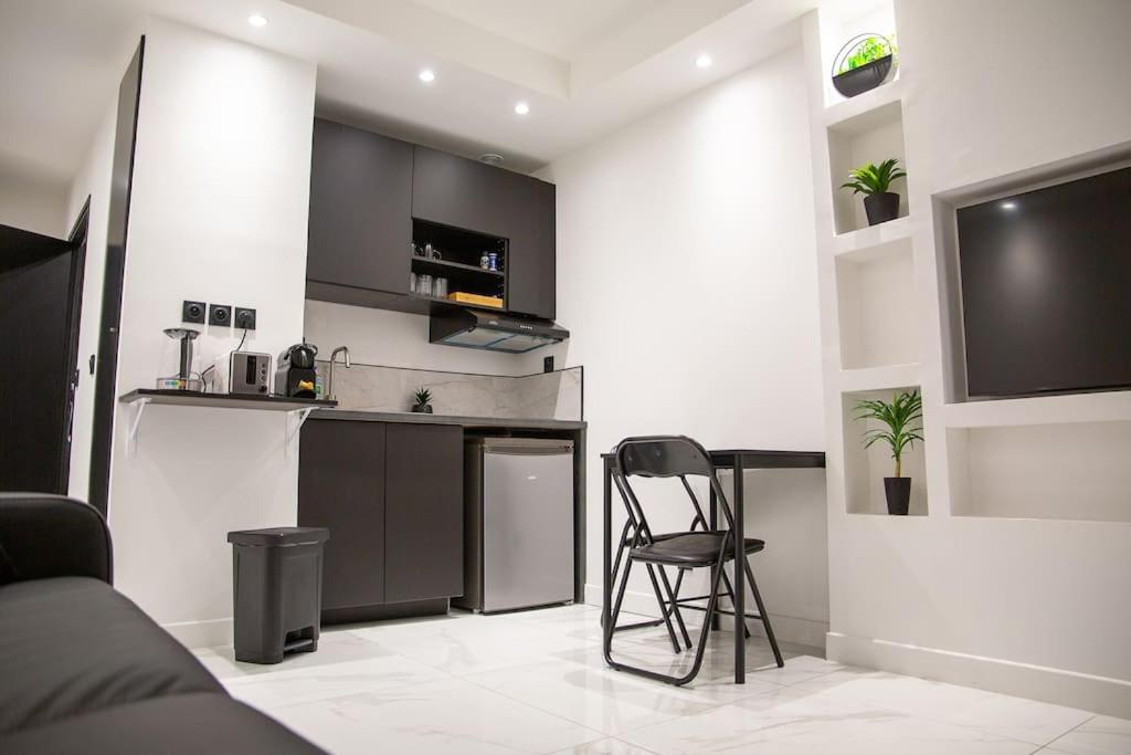 une cuisine avec une table et une chaise dans une pièce dans l'établissement Studio Chaleureux Part-dieu, à Lyon