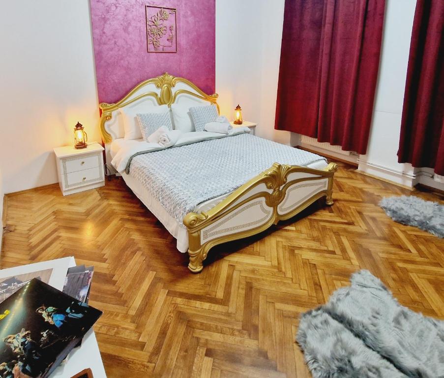 a bedroom with a bed and a wooden floor at Royal 5* mansion near central square in Cluj-Napoca