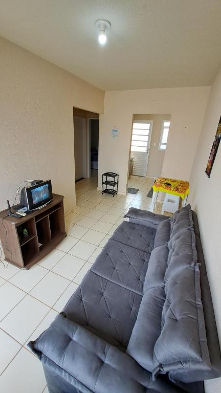 Cette chambre comprend un grand lit bleu et une télévision. dans l'établissement Casa Confortável Mobiliada, à Marília