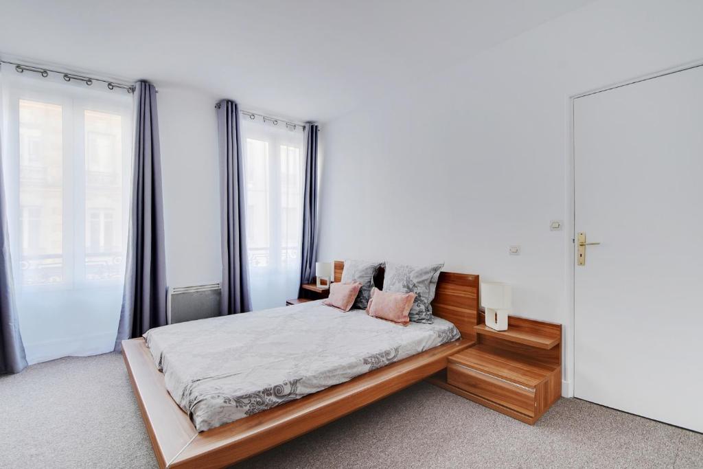 une chambre avec un lit et une grande fenêtre dans l'établissement CHAMPS DE MARS - GRENELLE, à Paris