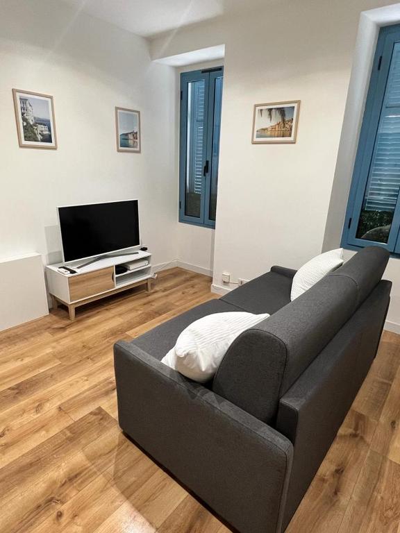 a living room with a couch and a flat screen tv at Studio Beausoleil porte de Monaco in Beausoleil