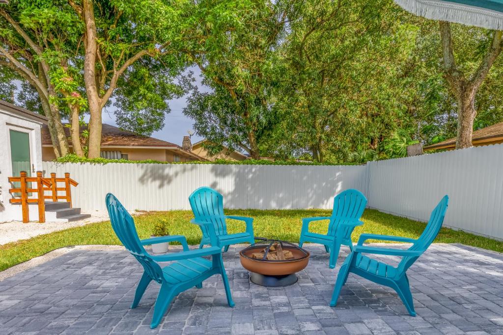 four blue chairs and a fire hydrant in a yard at Serenity Lodge Condo in Miami