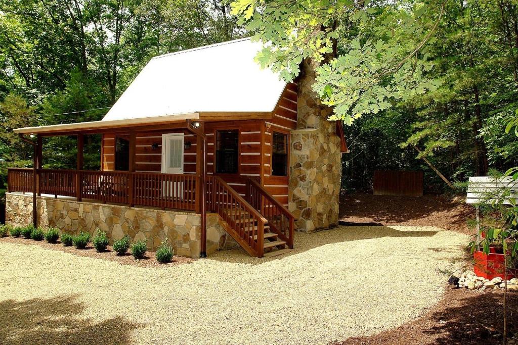 Cabaña de madera pequeña con porche y terraza en Mountain Laurel Cabin, en Cosby