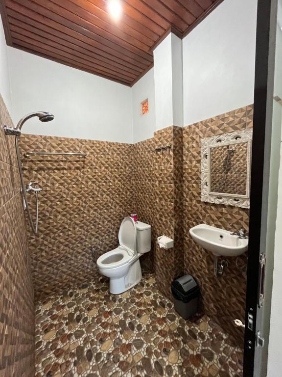 La salle de bains est pourvue de toilettes et d'un lavabo. dans l'établissement Nano Ari Homestay, à Ubud