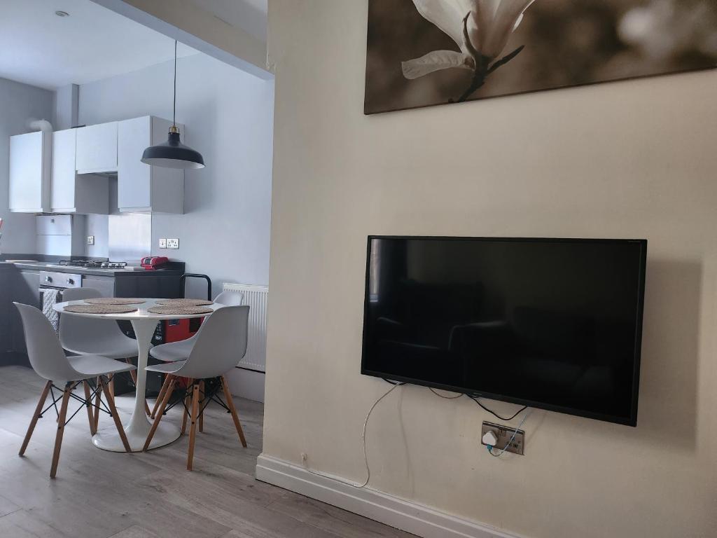 a flat screen tv hanging on a wall in a living room at Leopold House Liverpool in Liverpool