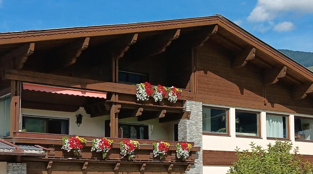 une maison avec des boîtes de fleurs sur le balcon dans l'établissement Gästehaus Huber, à Mittersill