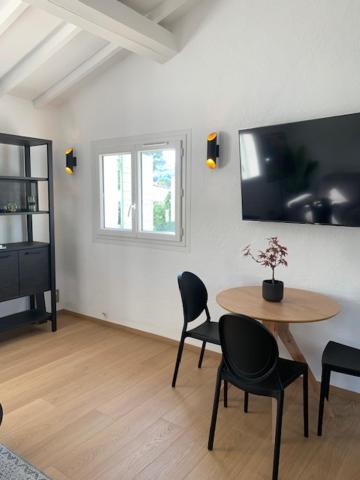 Zimmer mit einem Tisch, Stühlen und einem TV in der Unterkunft PROVENCE facile in Le Tholonet