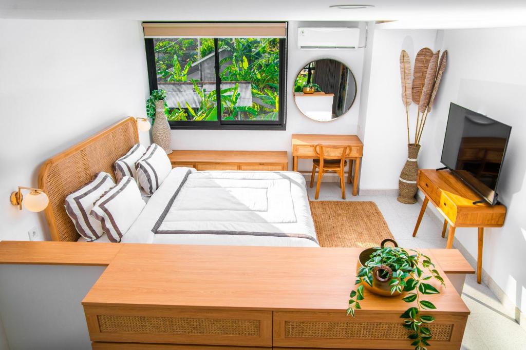 1 dormitorio con 1 cama grande y TV en KARRA LOFT - Bali Invest Club en Canggu