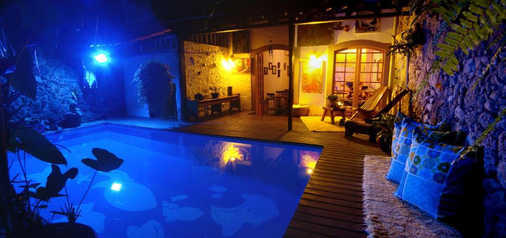 a swimming pool in a house at night at Pousada Arte Urquijo in Paraty