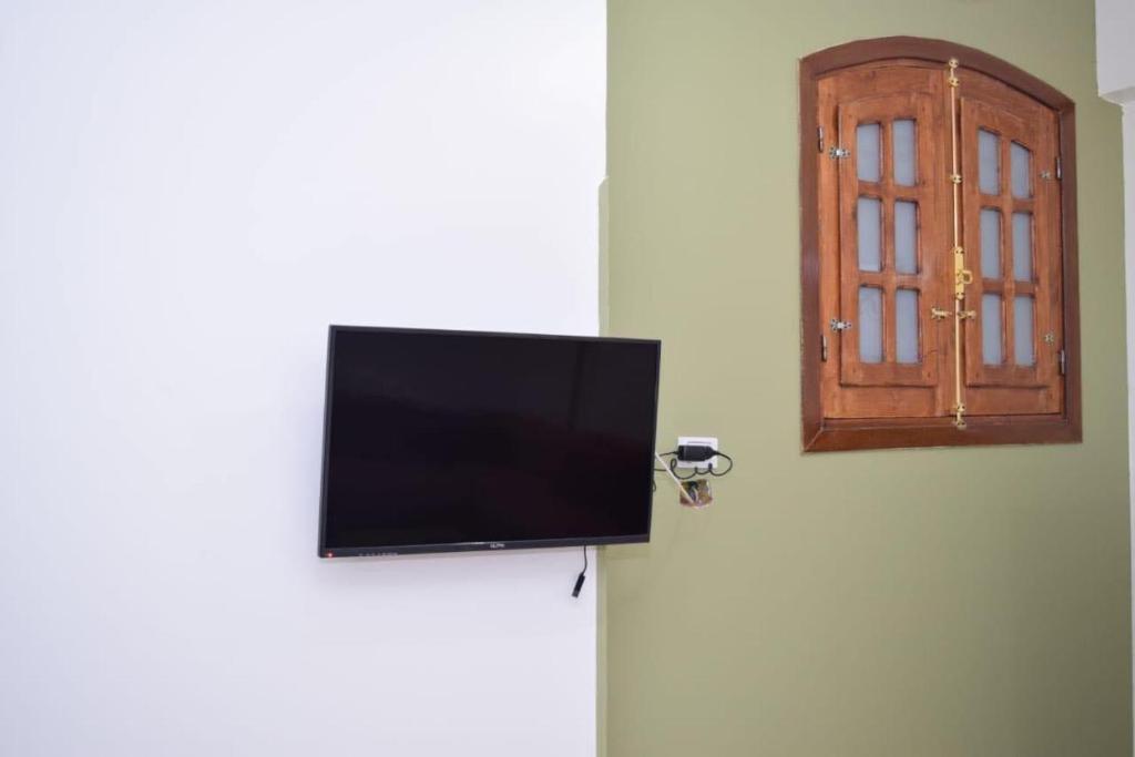 einen Flachbild-TV auf einem Kühlschrank mit Tür in der Unterkunft El hady apartments in Luxor