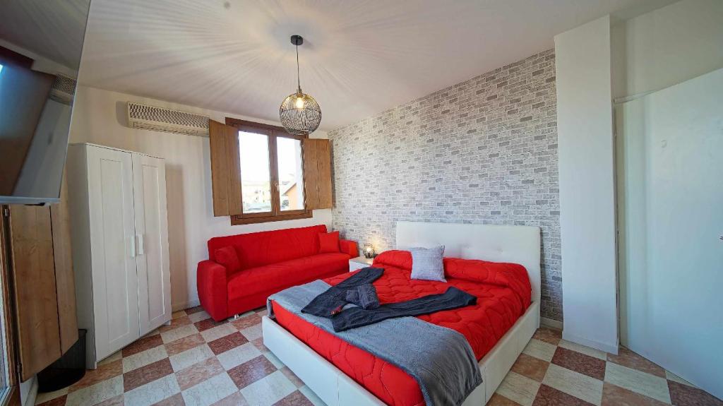 a bedroom with a red bed and a red couch at Destiny Home 7 Verona Fiera in Verona