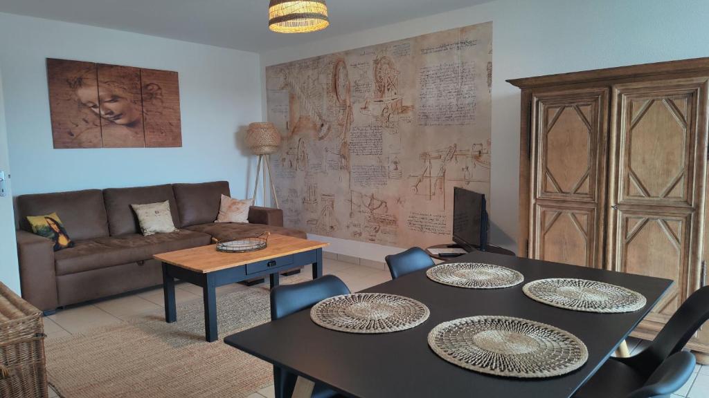 salon z dwoma stołami i kanapą w obiekcie Appartement Leonard de Vinci w mieście Montlouis-sur-Loire
