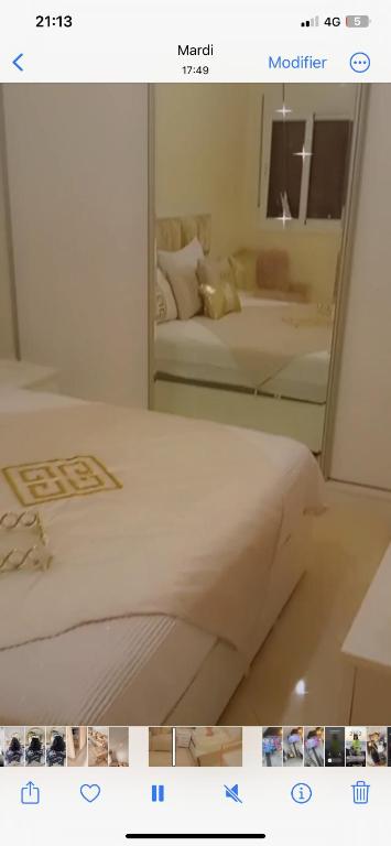 ein Bild eines Bettes in einem Zimmer mit Spiegel in der Unterkunft Hay agdal oujda in Oujda
