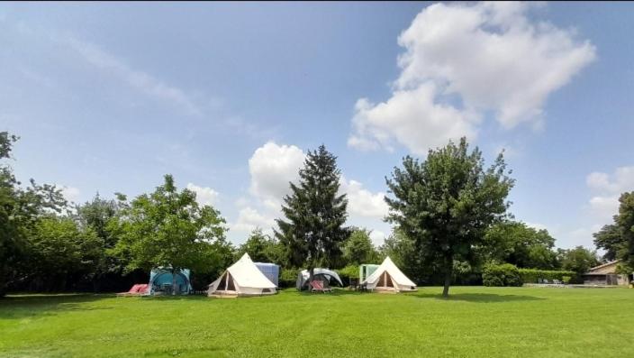 un groupe de tentes dans un champ arboré dans l'établissement Bellevues Glamping and Camping, à Mérignac
