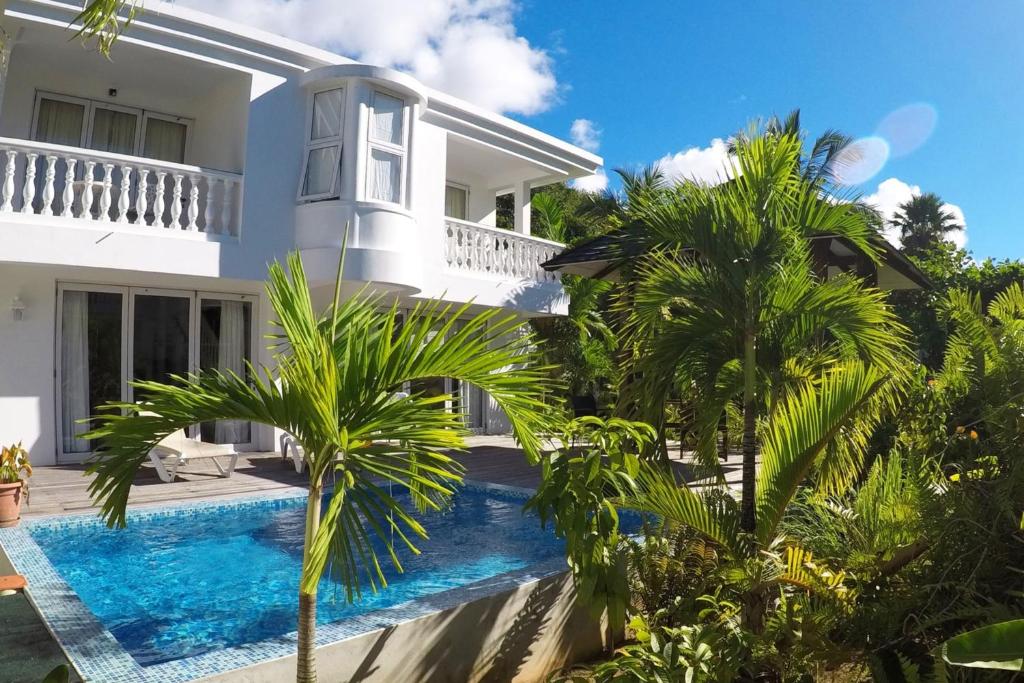 a villa with a swimming pool in front of a house at Chateau Elysium - Two bedroom villa 2 in Beau Vallon