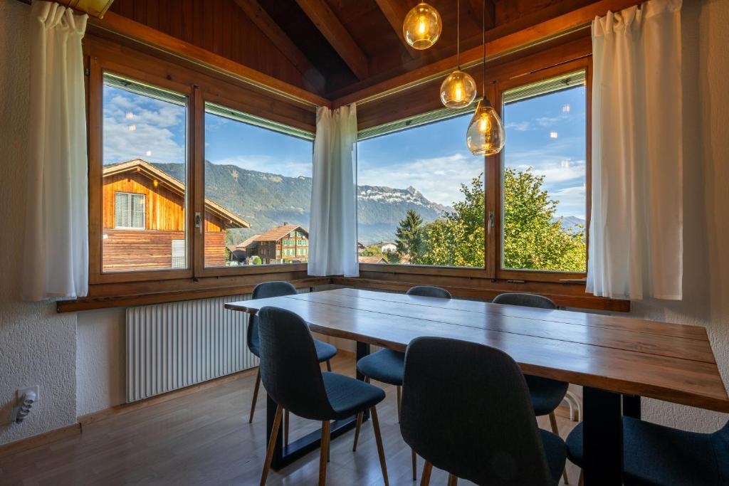 a large room with a table and chairs and windows at Alpenblick mit Balkon nahe Interlaken in Wilderswil
