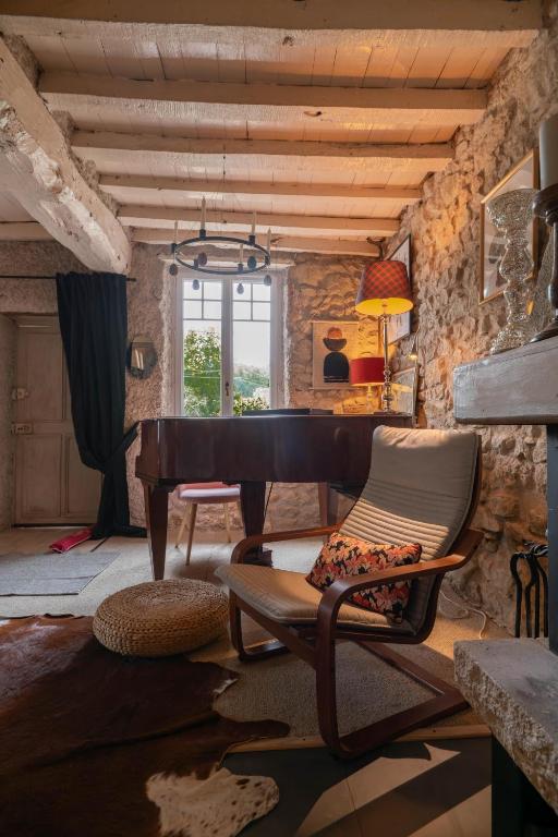 a living room with a piano and a chair at Grande Maison Creuzier - Villa 3 chambres et jardin in Creuzier-le-Neuf
