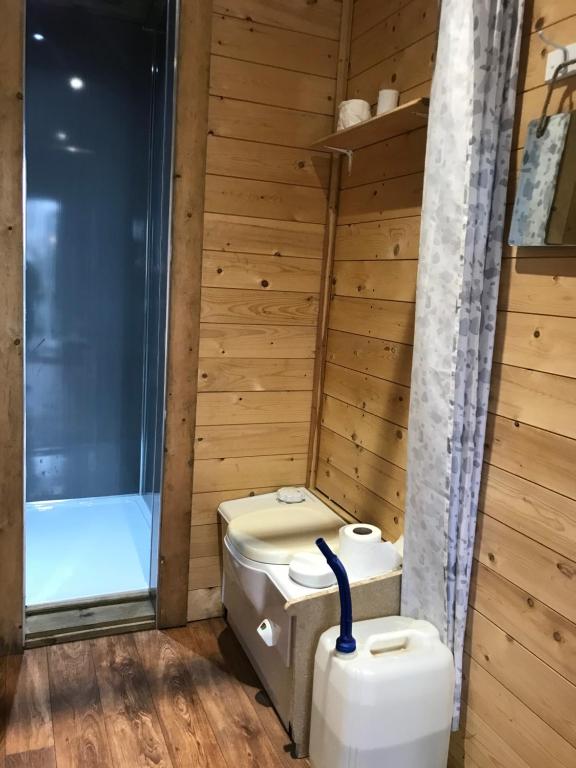 a bathroom with a toilet and a bath tub at Ogdenclough fisherie log cabin in Rochdale