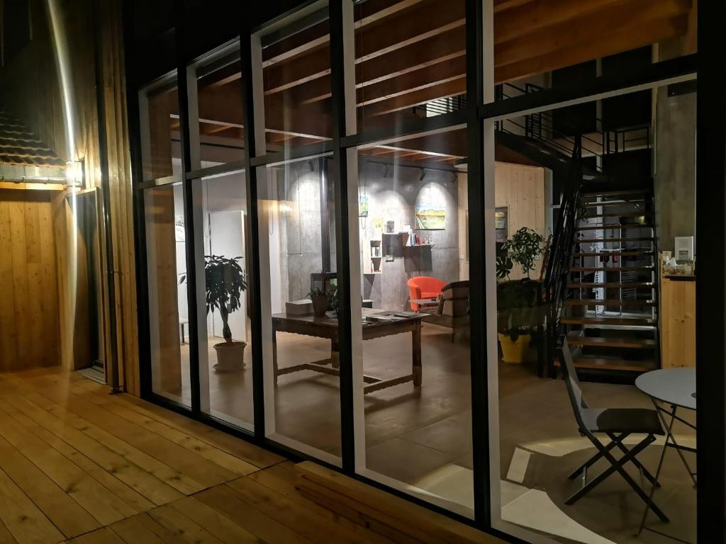 韋爾科爾地區拉沙佩勒的住宿－Aux Buis Gourmands，一间设有玻璃门和桌椅的房间