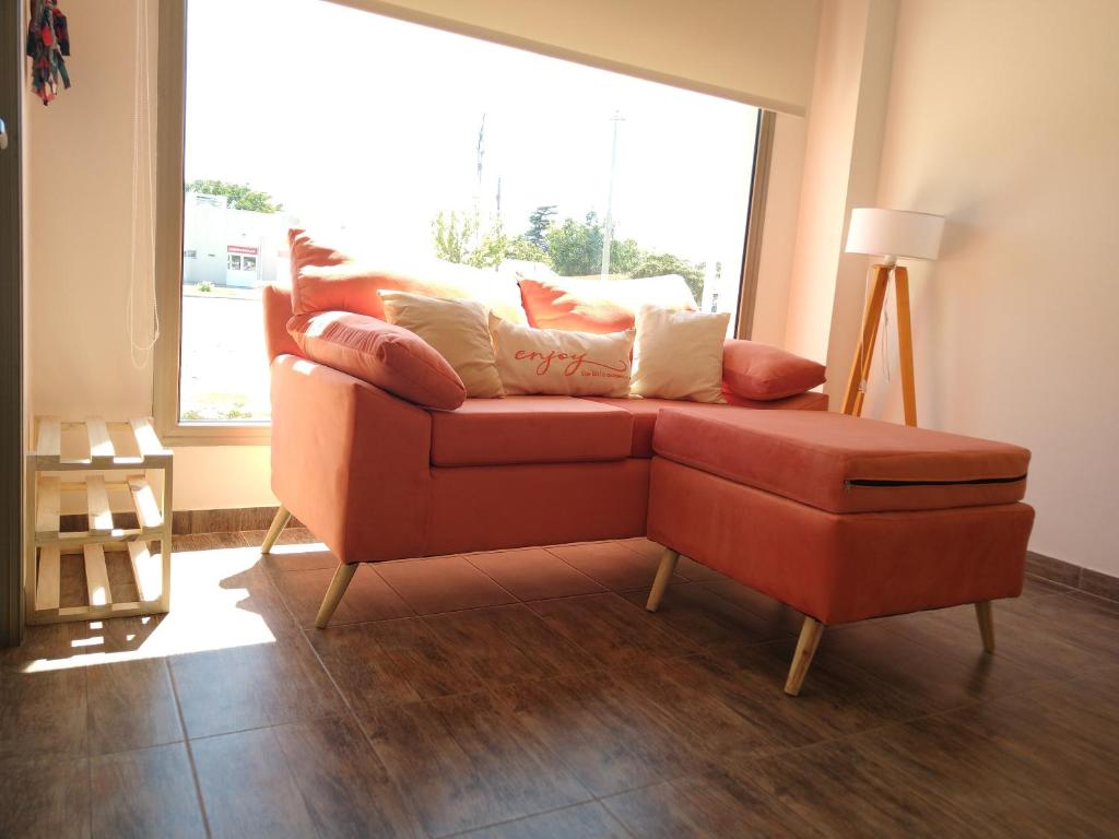 a living room with a red couch and a window at Complejo Vista Tres Picos in Sierra de la Ventana