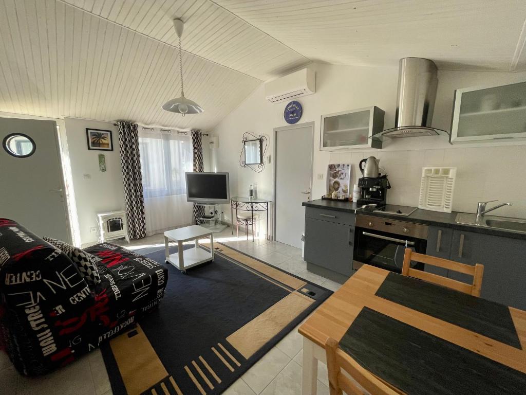 a kitchen and living room with a couch and a table at Charmante maison / Proche du lac de Casteljaloux in Casteljaloux