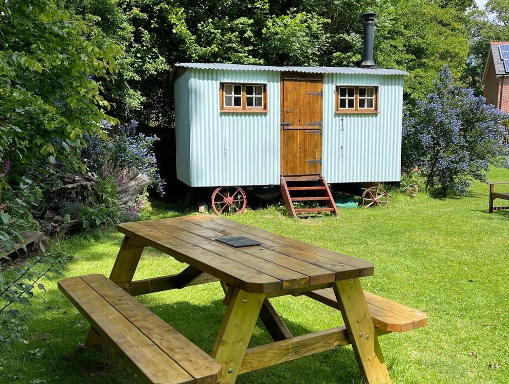een picknicktafel en een speelhuis in de tuin bij Fernwood in Ringwood