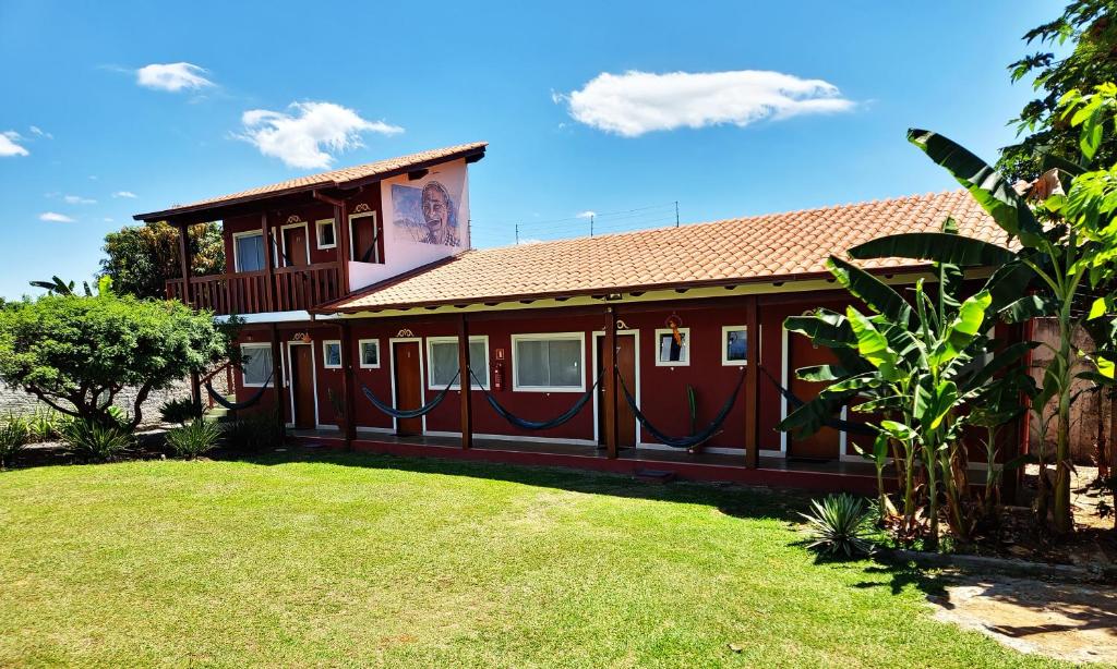 una casa con un patio verde delante de ella en Pousada Sertão, en Alto Paraíso de Goiás