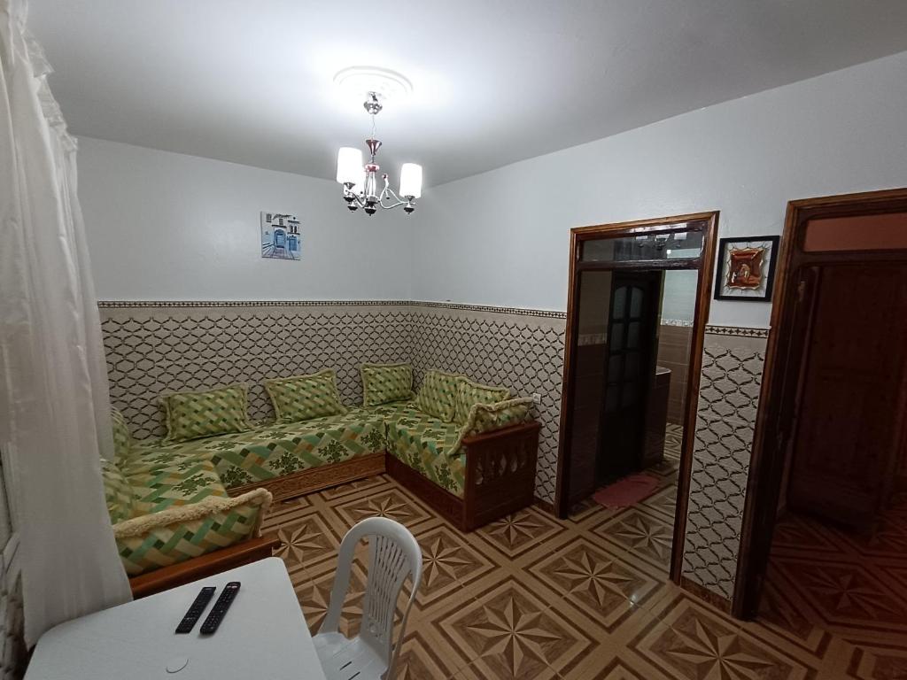 a living room with a green couch and a table at Dar ABDOL in Chefchaouen