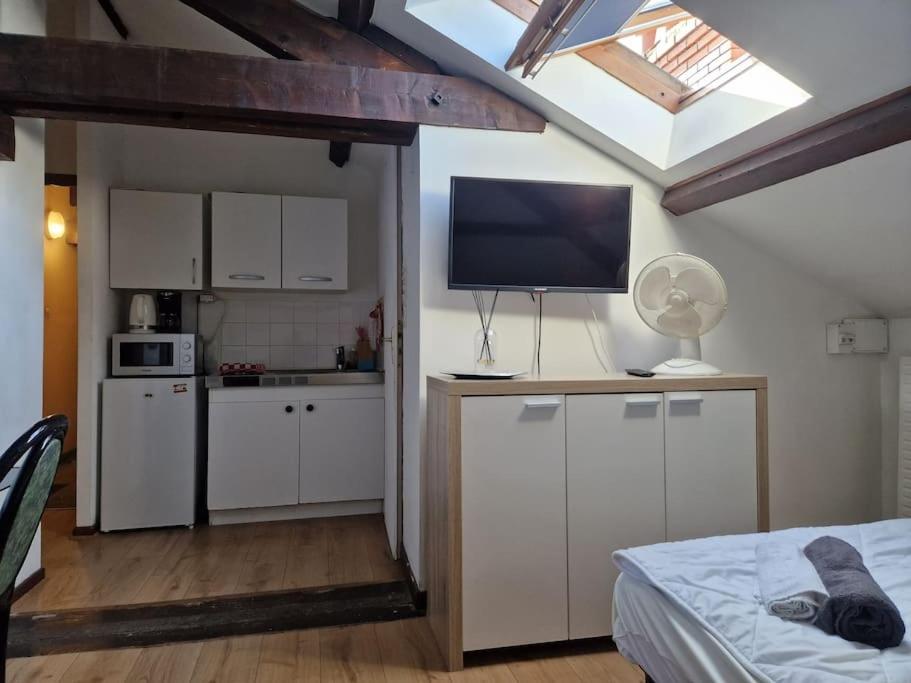um quarto com uma cozinha com uma cama e uma televisão em 5 verrerie em Chalon-sur-Saône