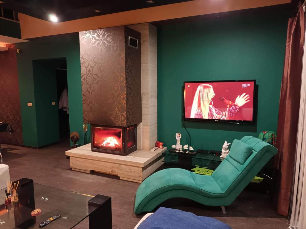 a living room with a fireplace and a green wall at Dom całoroczny na wynajem - Zalesie nad jeziorem Chełmżyńskim koło Torunia 