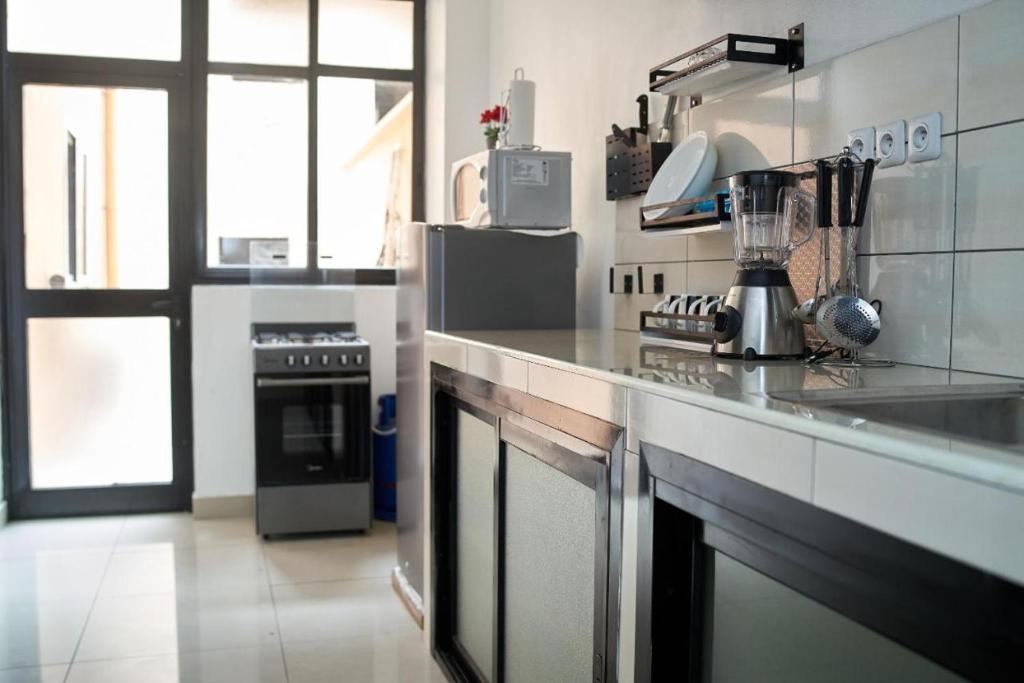 a kitchen with a stove and a counter top at appartement cosy free bonapriso in Douala