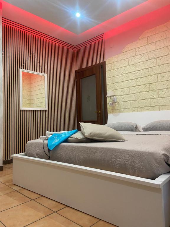 sypialnia z dużym łóżkiem z czerwoną ścianą w obiekcie b&b ERCOLANO Scavi w mieście Ercolano