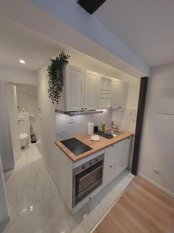 a kitchen with white cabinets and a sink at Studio apartman Mia in Zagreb