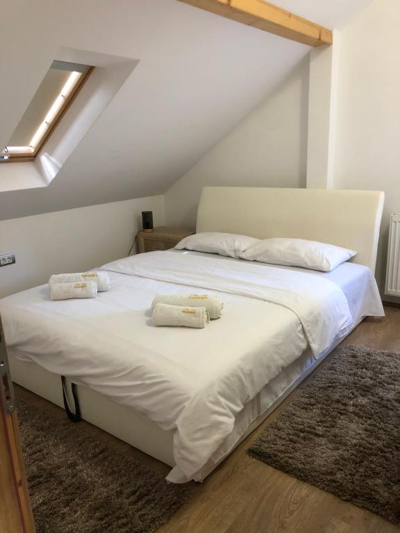 sypialnia z łóżkiem z białą pościelą i poduszkami w obiekcie Etno selo Milanovic - Nonac w mieście Kuršumlija